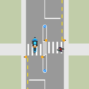 A blue motorcycle is driving northbound in the left lane while a pedestrian crosses at the pedestrian crossing in the right lane. There is a raised island in the middle of the pedestrian crossing.