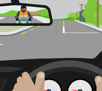 Point of view of a car driver at the wheel. A blue motorcycle and rider can be seen in the driver's rear view mirror.