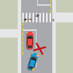 A red car is stopped at a pedestrian crossing and waiting for people to finish crossing. A blue car behind the red car is attempting to pass the red car. A large red X indicates this is the wrong thing to do.