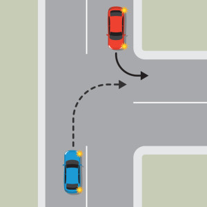 A red car is indicating to turn left at an intersection. An oncoming  blue car is indicating to turn right into the same lane. The blue car must give way to the red car.