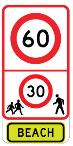 White sign with red outline showing 60 within a red circle, then 30 within a red circle surrounded by pedestrian images