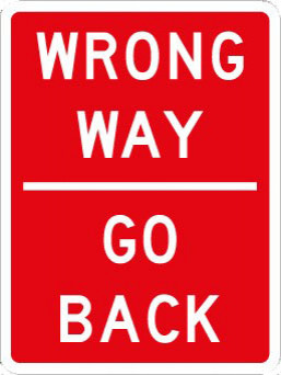 Traffic sign with words wrong way, line in the middle and another words saying go back underneath on a red background