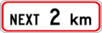 Traffic sign which says next 2 km with a red rectangular border