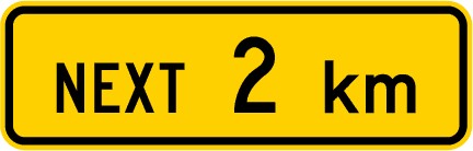 Traffic sign which says next 2 km on a yellow background