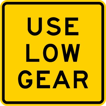 Traffic sign which says use low gear on a yellow background