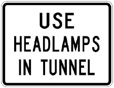 Tunnel sign which says use headlamps in tunnel on white rectangular background