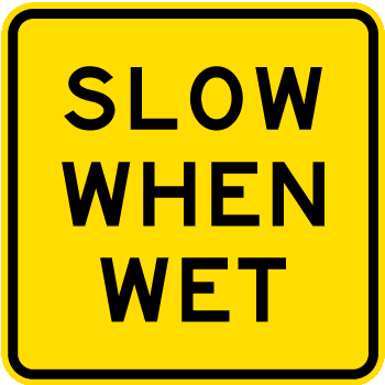 Traffic sign which says slow when wet on square yellow background