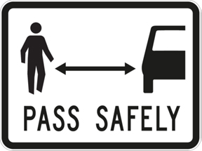 Sign showing person and a car with the words pass safely