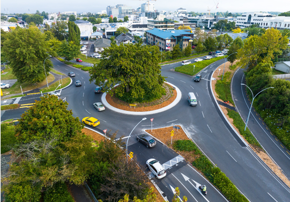 Photo from a birds eye view of a roundabout with traffic driving around it, with newly installed raised safety platforms