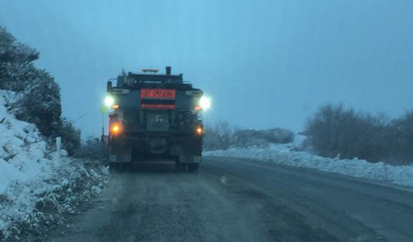 Truck spreading grit in snowy conditions