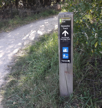 A wayfinding post beside a gravel trail.