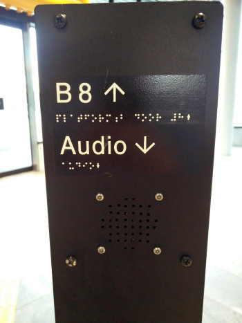 A wayfinding post with braille
