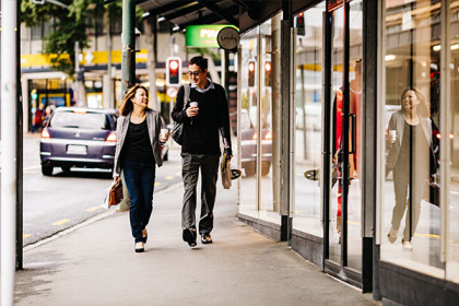 Man and woman walking along a retail street in urban centre.