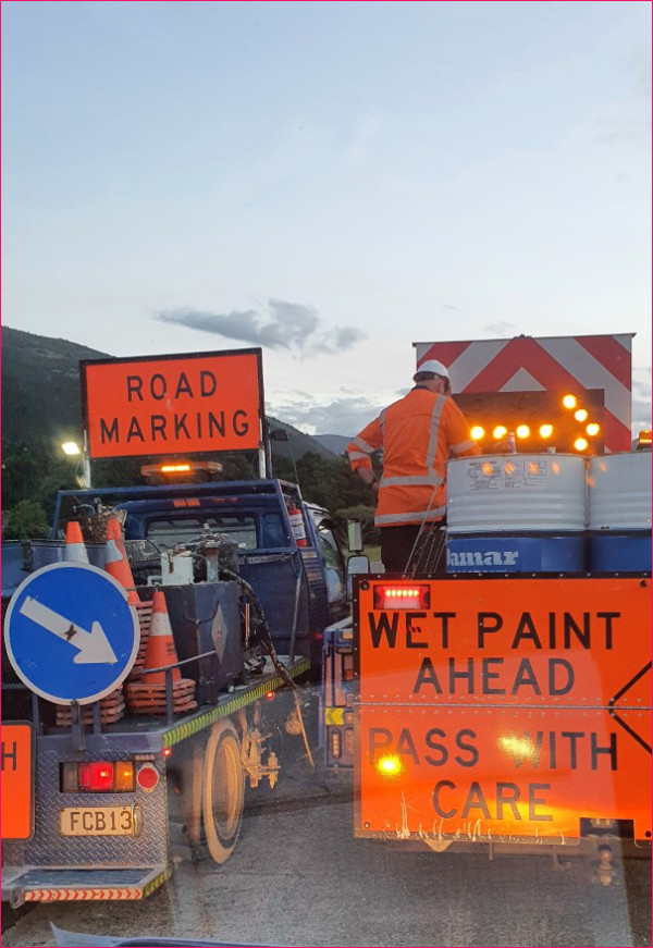 Signs showing road marking and wet paint ahead