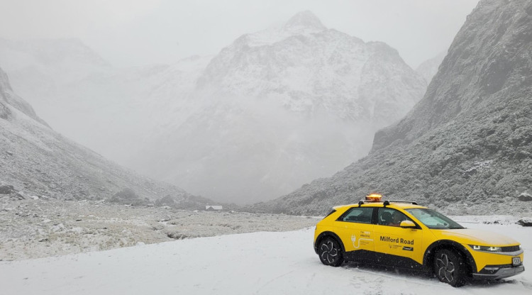 yellow electric vehicle against the snow mountain road