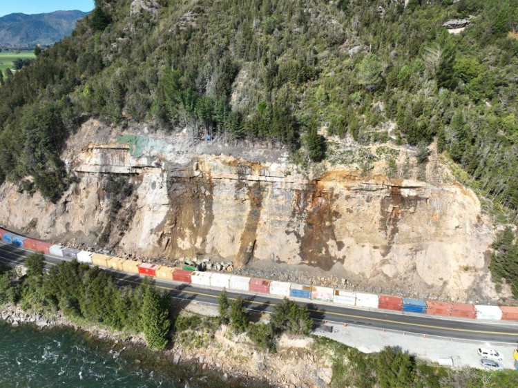 aerial view of the coastal road with barrier wall with freight containers lined up 