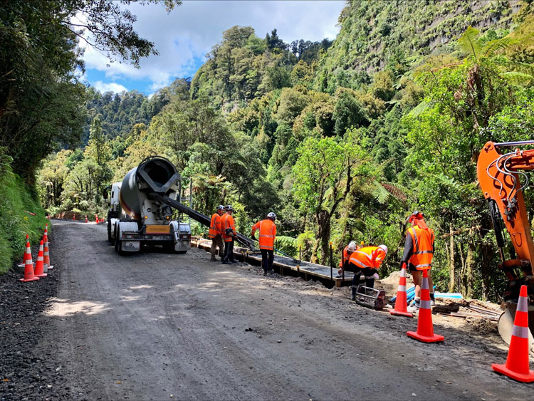 work crew on unsealed road doing pavement works