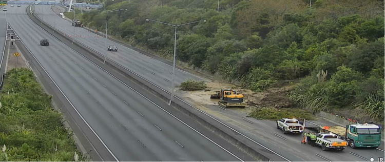 Slip on a main state highway road with heavy machinery at work clearing the debris.