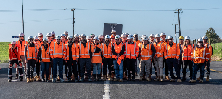 A team of construction workers gathered and posing for a photo, demonstrating unity and pride in their work at the construction site.