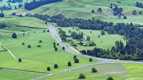 Long distance view of rolling hills and a highway road