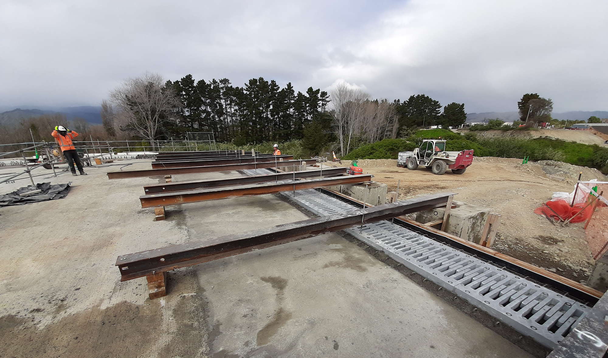Steel beams laid on top of concrete base.