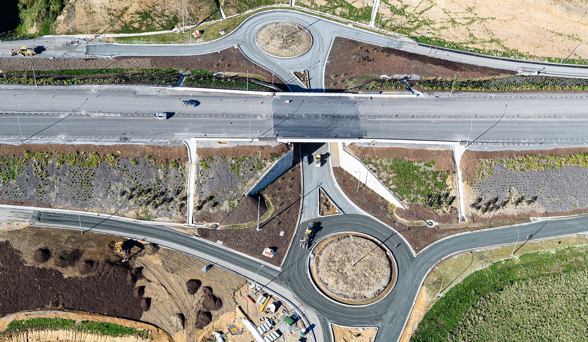 Aerial view of two roundabouts on either side of the motorway.