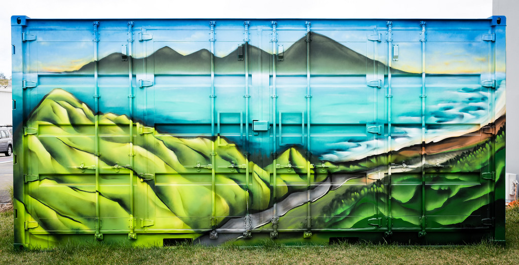 Colourful mural of coastal road painted on shipping container used as Transmission Gully mobile visitor centre