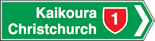 A green rectangle with white border. The right side of the border is shaped as an arrow tip. White text reads Kaikoura and Christchurch with a red shield sign.