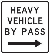 White information sign saying heavy vehicle by pass with an arrow point right