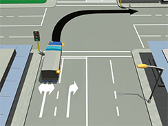 At a controlled traffic light intersection which is showing a green light, a heavy vehicle on the left of two marked lanes is signalling to make a 90 degrees right turn keeping to the left lane. There is no visible traffic at this intersection.