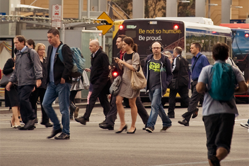 A group of people walking past a bus