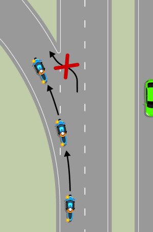 A blue motorcycle is using the off-ramp to exit the motorway. Black arrows show the motorcycle should stay in the centre of the lane and indicate left. A red cross shows it should not turn at a sharp angle, if it travels too far past the exit.