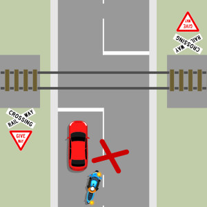 A red car is stopped in front of railway tracks. To the left are 2 signs that read give way and railway crossing. A blue motorcycle indicates to pass the car. A red cross shows this is the wrong thing to do.