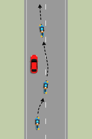 A blue motorcycle is travelling in the left-hand lane, behind a red car. The motorcycle signals right, moves around the right-hand side of the car, then indicates left to move in front of the car.