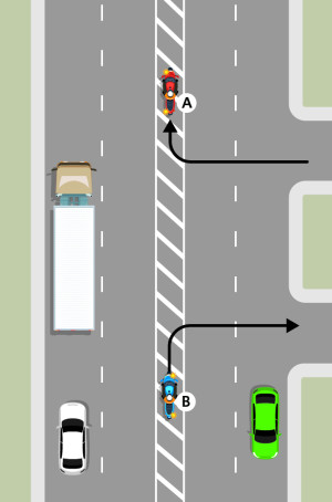 A 4 laned road with a flush median in the centre. A blue motorcycle marked vehicle B is waiting on the diagonal lines, indicating to turn right. A red motorcycle marked vehicle A has turned right from a side street, onto the flush median.
