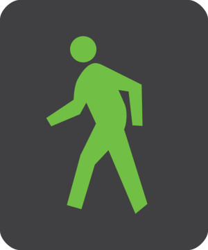 A green person with their arms and legs posed in a walking position on a black background.