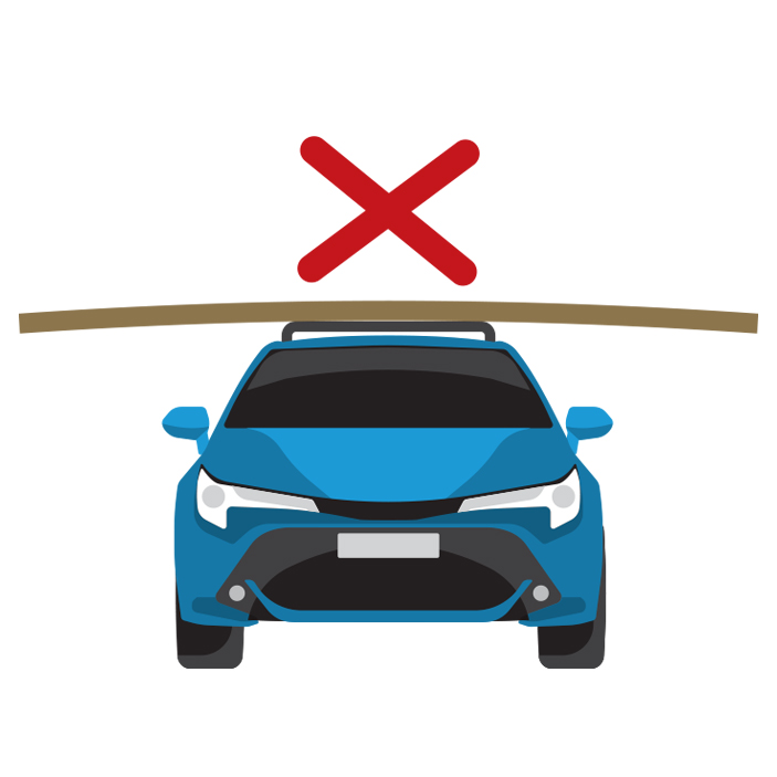 Front view of a blue car incorrectly carrying a load which extends too far over both sides of the vehicle.