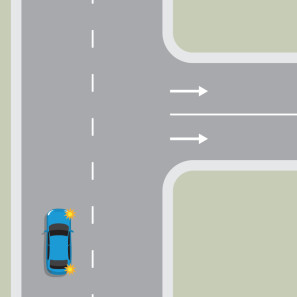 A blue car is indicating to turn right into a one-way street with two lanes.