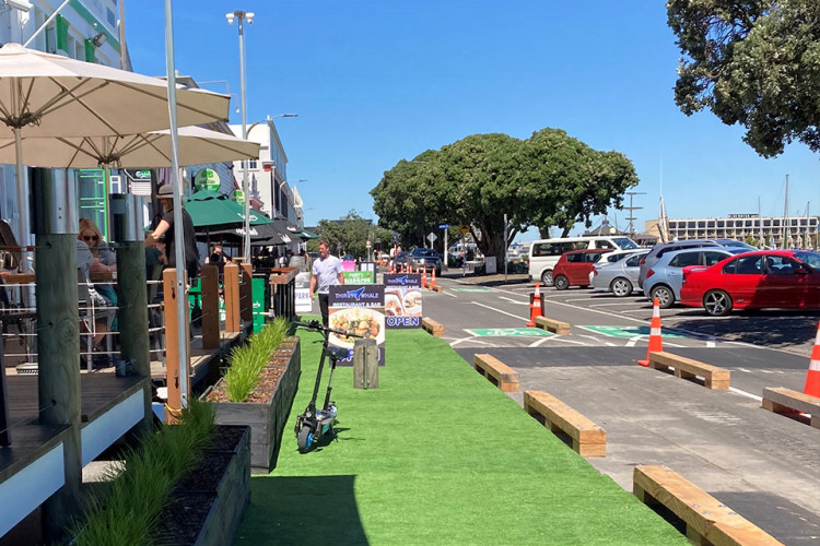 A road with pop-up footpath extension and cycleway using astroturf and wooden horizontal separators