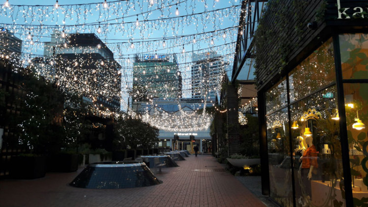 Street decorated with hanging strings of lights at dusk