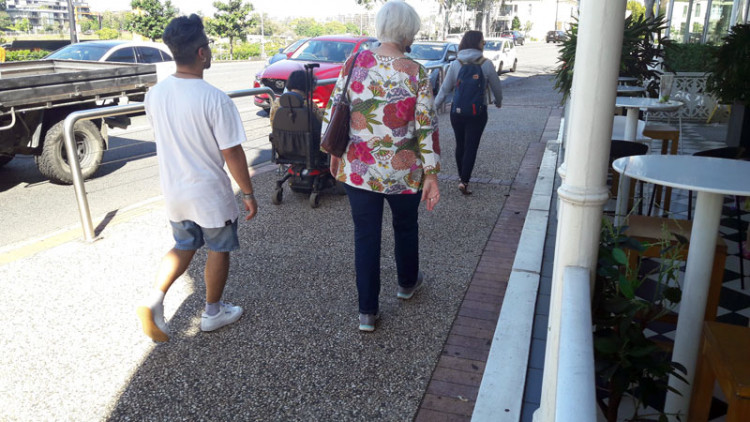Elderly pedestrians and a wheechair person on footpath made of non-slip materials 