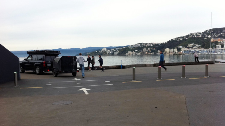 A car and trailer accessing the waterfront over retracted bollards.