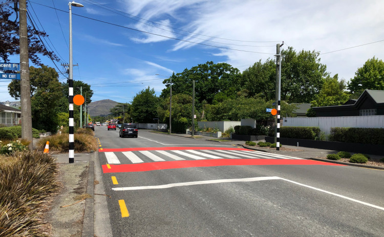 A pedestrian crossing with red paint across the road.
