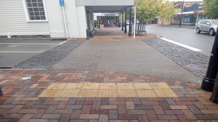 A photo of a raised safety platform at a side road taken from the footpath and showing different surfacing of the platform compared with the footpath.  