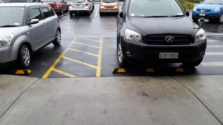 Parking spaces marked with yellow lines, showcasing accessible paths being kept clear.