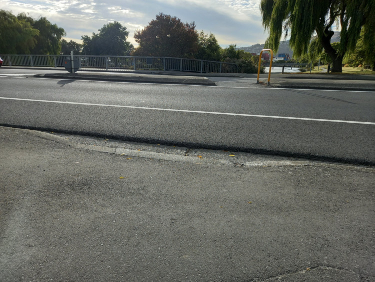 The road asphalt overlay has created a high lip at the crossing point which is a tripping hazard and will make it difficult for wheeled devices.