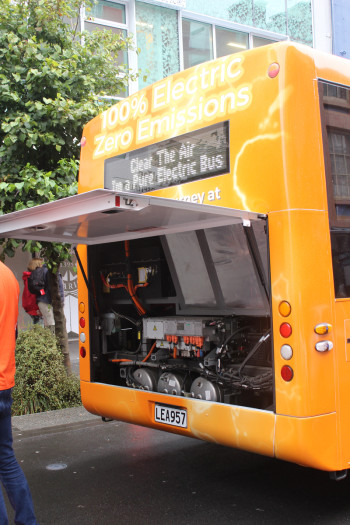 An electric bus displaying “Clear the air, I’m a pure electric bus” on the back
