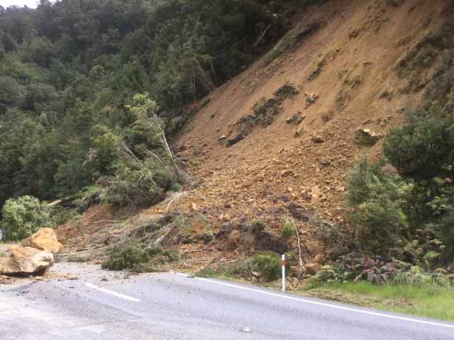 Trees and large rocks cover road at Knights Point on State Highway 6