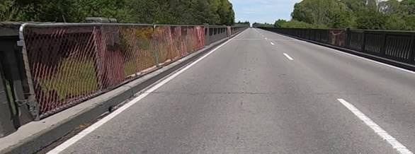 Rakaia River bridge with no traffic on it and metal wire temporary fencing in place of missing concrete barrier panels.