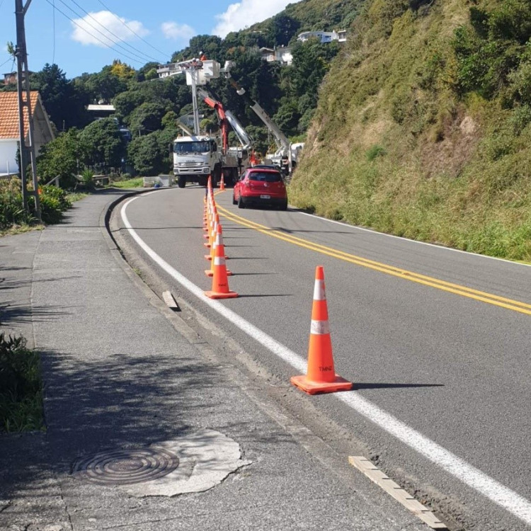 contractor fixing power pole on state highway road